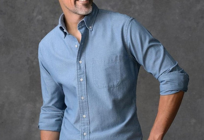 Um homem vestindo um bela camisa azul (lavagem jenas) feita sob medida da marca Perfetto Alfaiataria.